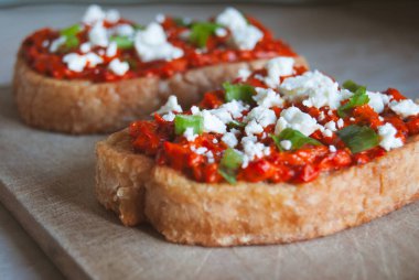 Ajvar geleneksel Balkan ev yapımı kırmızı biber ezmesi bir dilim ekmek üzerine beyaz peynir ve taze soğan