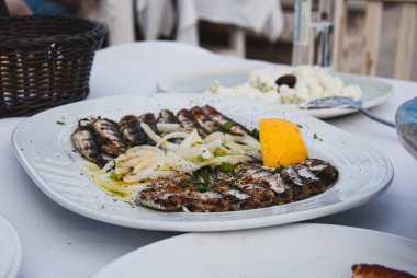 Limonlu, otlu, soğanlı, sardalyalı ızgara balık.