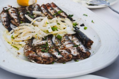 Limonlu, otlu, soğanlı, sardalyalı ızgara balık.