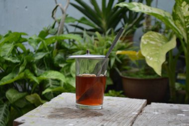 Bir fincan çay ve siyah arka planı olan bir kavanoz.