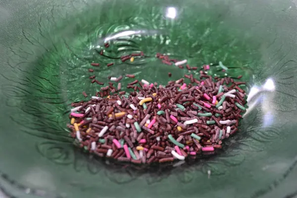 Bir kaşık ve çiçekli renkli bir bardak çay.