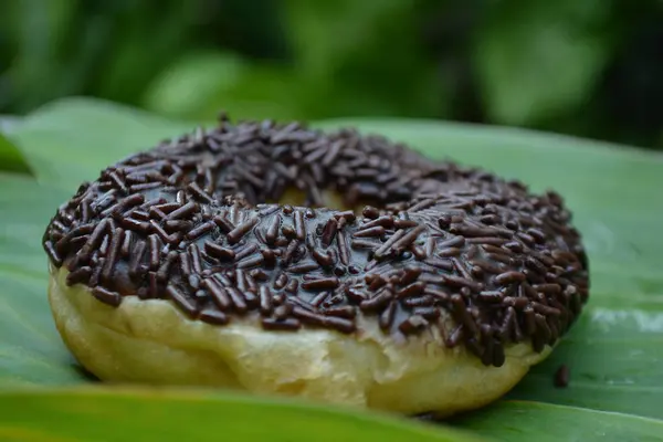 Arka planda çikolatalı çörek ve muz yaprağı.