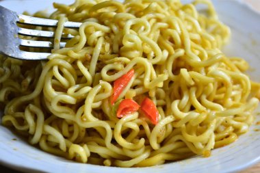 Beyaz tabakta tavuk ve biberli kızarmış erişte..