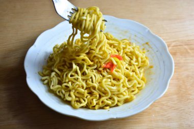 Çubuklu kırmızı bir kasede erişte.