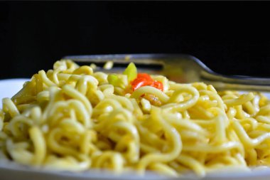 Kızarmış erişte ve bir kaşıkla sebze..