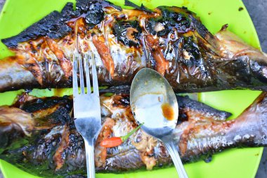 Baharatlı soslu ızgara balık ve salata.