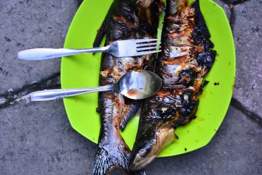 Tahta zemin üzerinde limonlu ve sarımsaklı kızarmış balık.