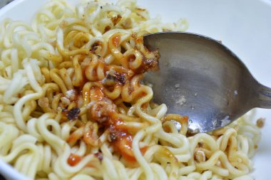 Masadaki beyaz tabakta et soslu makarna, yemek pişirme süreci....