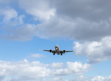 Yolcu uçağı bulutlu mavi gökyüzünün arka planına doğru uçar. Yetişkin aracıyla seyahat etmek