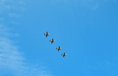 Mavi gökyüzünün arka planında uçan askeri uçaklar, uçak geçidi.