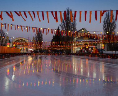 Bir kış Noel akşamında karlı buz pateni pisti, parlak Noel arkaplanı.