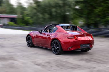 Kyiv, Ukrayna 05 / 29 / 2024. Kırmızı Mazda spor üstü açık pistlerde hız yapıyor ve sürücü güneşli bir günde sürmenin heyecanını yaşıyor..
