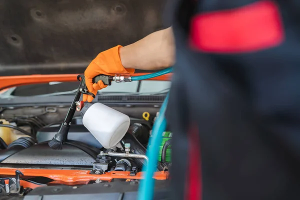 Asyalı Bir Erkek Işçi Motoru Temizlemek Için Hava Üfleyici Kullanarak — Stok fotoğraf