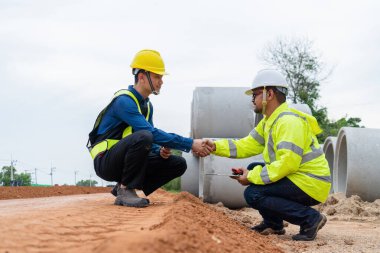 Asyalı inşaat mühendisleri başarılı bir proje sonrasında müteahhitlerle el sıkışıyor.
