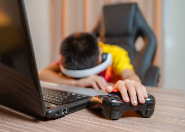 Oyun denetleyici görme ve çocuklarda görme sorunları olan Asyalı çocuğun oyun oynarken başı dönüyor