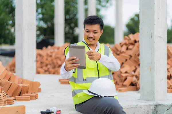 Inżynier Siedzi Przy Projekcie Budowlanym Trzymając Tablet Selfie Czacie Szczęśliwie — Zdjęcie stockowe