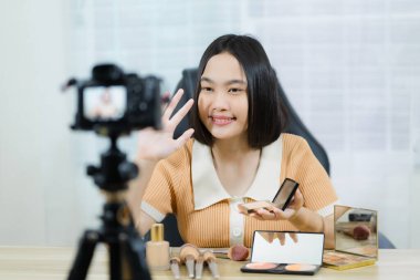 Genç güzel Asyalı kız, profesyonel ya da blogcu, sosyal medyada paylaşmak için makyaj yapıyor..