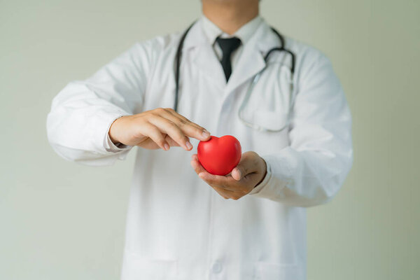 Рука азиатского врача с красным сердцем показывает признаки любви