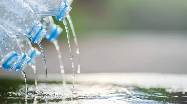 Water Flowing Several Plastic Drinking Bottles Concrete Floo — Stock Photo, Image