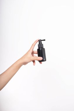 Kadın elinde markasız bir şişe serum, cilt bakımı ve kozmetik konsept, serum ya da kozmetik modelleme.