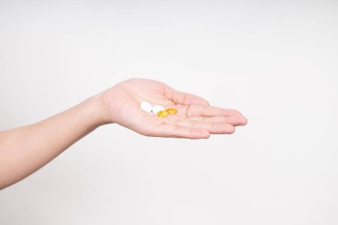 Kadın elleri birden fazla hap, D3 ve Zinc vitamini alıyor. Beyaz arka planda izole edilmiş günlük vitaminler.