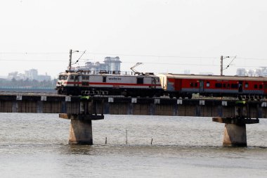 Hindistan demiryolu treni Kerala 'da nehir üzerindeki bir köprüde çok hızlı hareket ediyor.