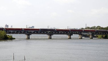 Hindistan demiryolu treni Kerala 'da nehir üzerindeki bir köprüde çok hızlı hareket ediyor.