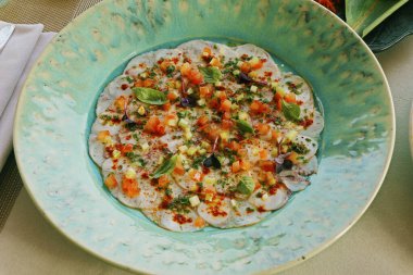 yeşil tabakta yeşil zeytin soslu ahtapot carpaccio