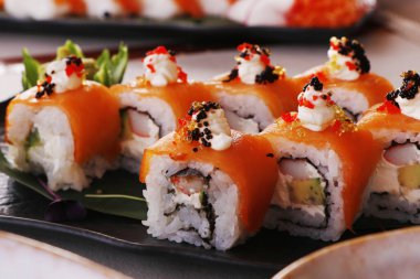 Suşi rulolarını avokado, yengeç, somon, çok renkli yumurta ve soya sosuyla yakın çekim yapın.