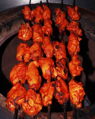 Hint baharatı marine edilmiş tavuk küpleri (tavuk tikka) tandoor olarak bilinen kil fırında pişirilen şişler.