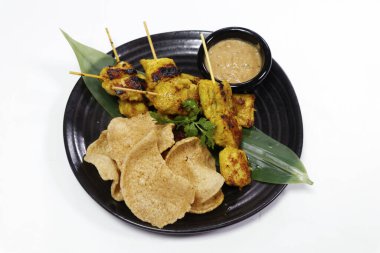 Otantik Asya sokak yemekleri fıstık soslu tavuk satay ve bambu yapraklı karides krakerleri.