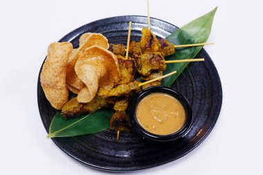Otantik Asya sokak yemekleri fıstık soslu tavuk satay ve karides krakerleri.