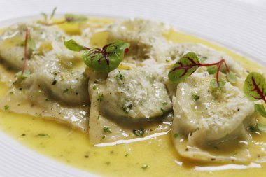 İtalyan yemeği, mantarlı ravioli makarna kremalı parmesan peyniri soslu beyaz tabakta.