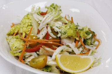 Ahtapot, karides, mürekkep balığı, marul ve domatesli deniz ürünleri salatası.