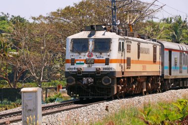 Kochi, Kerala, Hindistan - 5 Mart 2021 Hint tren yolu boyunca elektrik desteği ile hareket eden bir tren.