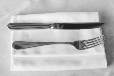 Restoran çatal bıçak seti, bıçak ve çatal peçeteli bir masanın üzerinde.
