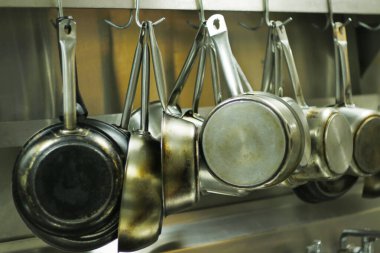 kitchen utensils, pans and pots hanging with hooks clipart