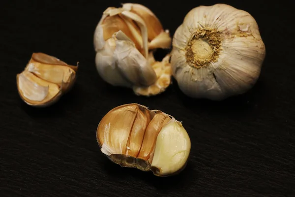 crushed Garlic cloves separately on a black background