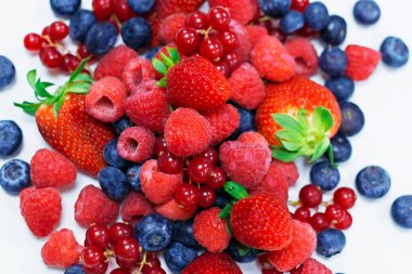 Beyaz parlak arkaplanı olan çeşitli taze meyveler.