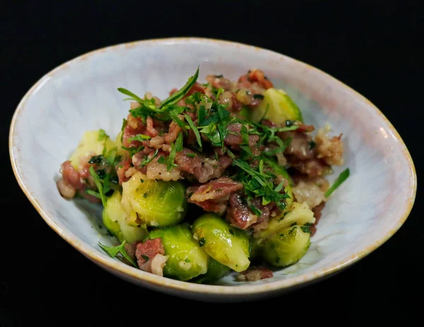 Kavrulmuş brussel lahanası ve kasede sığır pastırması.