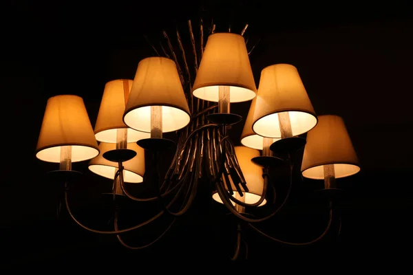 Luxury lighting lamps in night room closeup, ceiling interior home decoration background