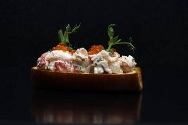 Istakoz rulo açık yüzlü sandviç. Siyah arka planda yakın plan.