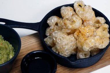 Kurumuş güneş ve yağlı fritöz çıtır domuz derisi servis tabağında 