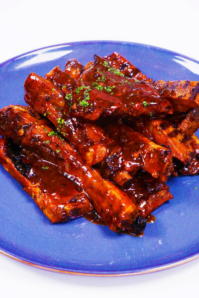 barbeque sauce glazed baby pork ribs in a plate with white background