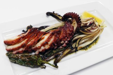 Izgara Akdeniz usulü ahtapot dokunaçlı asma biber, hindiba ve limon dilimleri.