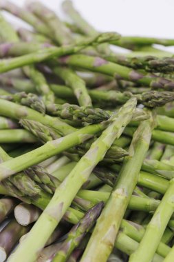 Beyaz arka planda taze yeşil kuşkonmaz grubu