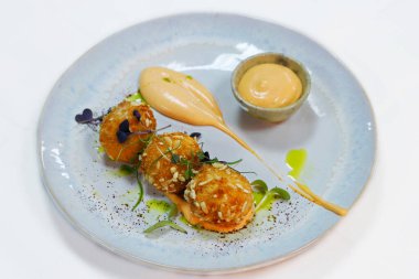 Baharatlı mayonez soslu kızarmış balık köftesi.