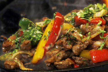 Meksika yemeği tüttüren tavuk ve sığır fajitası sıcak tabakta