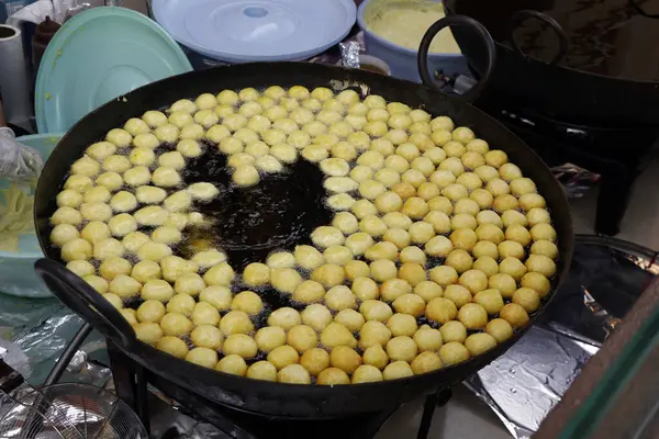 arabic street food Logma or Legaimat (Lugaimat) preparation, is one of the most popular Emirati sweets in united arab emirates, UAE,served with dates syrup or honey