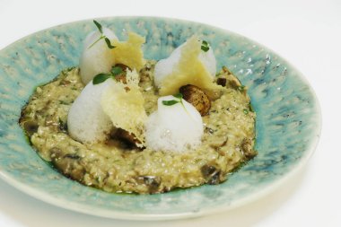 Kremalı mantarlı risotto, İtalyan pilav spesiyali çıtır parmesan peyniri, köpük ve bitkilerle birlikte.